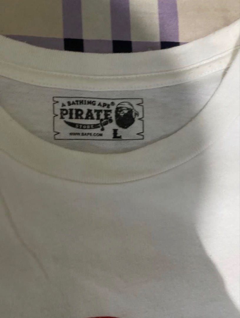 BAPE Pirate Store T-shirt - White - Large (Category: Tshirts & Polo Shirts ) located in Batangas. Submitted by aidenbotchog (Listing ID 1430105044, Image 2). Description: Authentic BAPE Pirate Store T-shirt in white. Features the iconic pirate ape graphic on the front. Made from 100% cotton. Size is Large. Includes the BAPE tag on the neck and a small logo on the sleeve. Made in China..