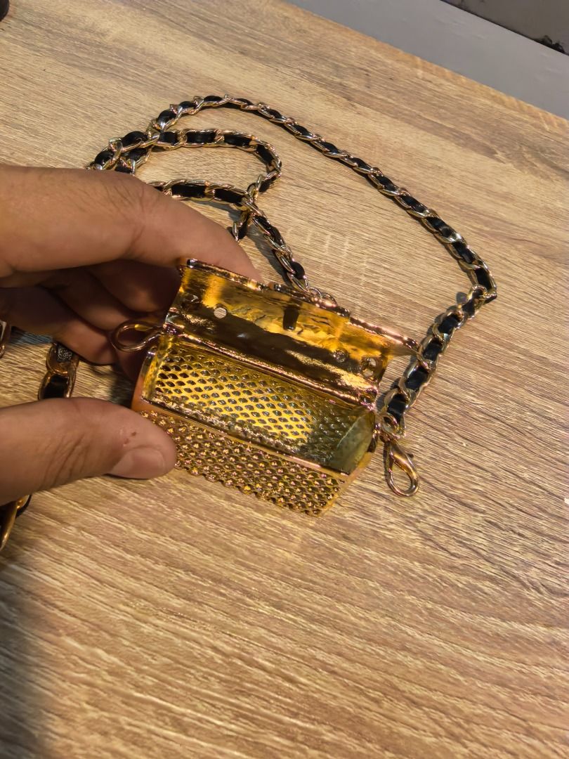 Chanel Gold Mini Bag with Chain (Category: Luxury Bags & Wallets) located in Cebu City. Submitted by esrpreloved (Listing ID 1429998095, Image 3). Description: Mini bag features a gold quilted design with a chain strap. The bag has a Chanel logo on the front. The chain strap is black and gold. The bag has a clasp closure. The bag is small and likely designed to be worn as a necklace or crossbody..