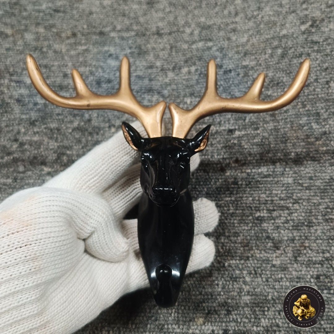 Deer Head Wall Hook - Decorative (Category: Wall Decor) located in Meycauayan. Submitted by ka_luma (Listing ID 1430064826, Image 1). Description: Decorative wall hook features a deer head design with a black body and gold antlers. It has a hook at the bottom for hanging items. The back has a rectangular area for mounting. It's a stylish addition to any room, perfect for coats, bags, or keys..
