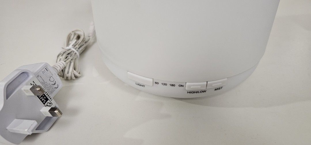 Essential Oil Diffuser (Category: Home Fragrance) located in Singapore. Submitted by lmproj (Listing ID 1430148355, Image 3). Description: - Dimensions: Diameter 17cm x Height 12cm. - Timer Setting: 1H/ 2H / 3H. - 500ML Aroma Diffuser with local SG 3 Pin Plug (Safety Mark Approved). - 8 LED changing light colours to choose. - Comes with mist function. It will auto-off when waterless to protect the machine from being damaged. - Can be used as a LE