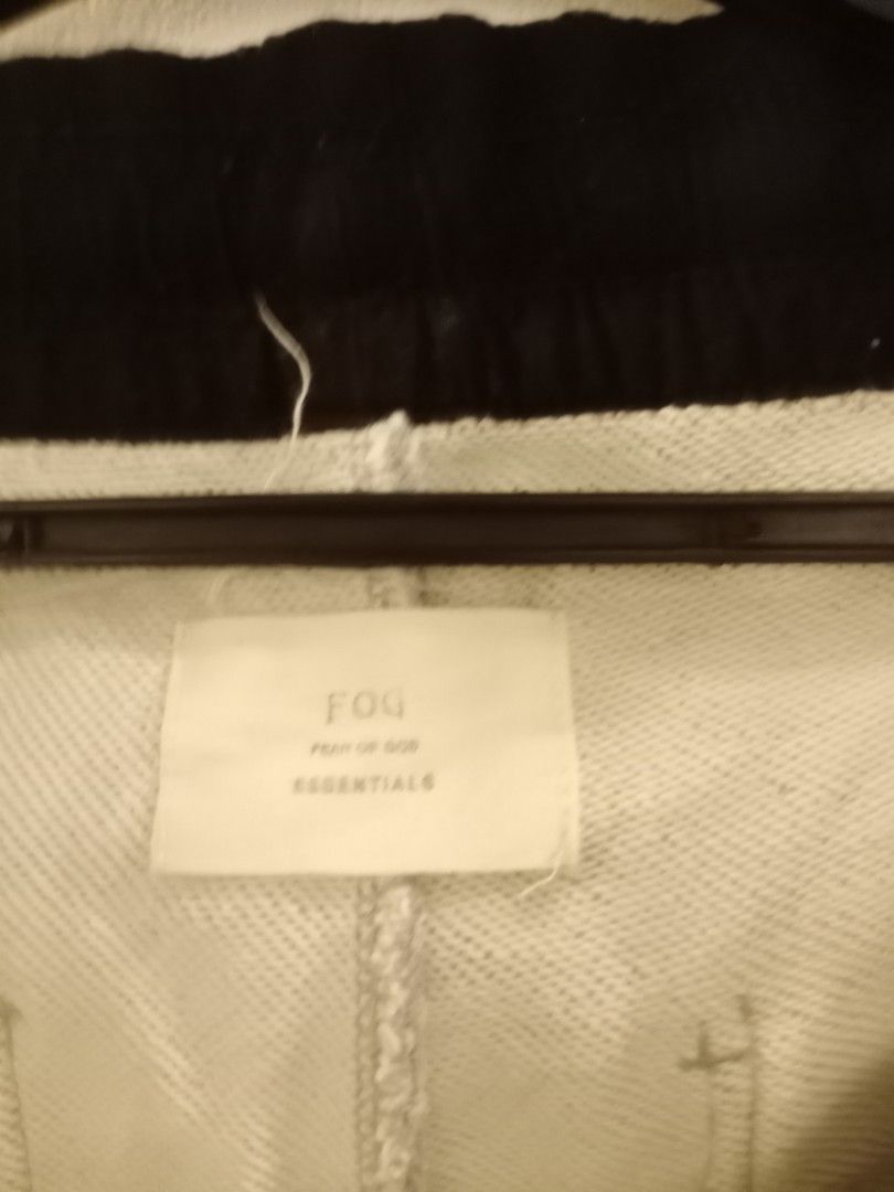 Fear of God Essentials Sweatpants (Category: Joggers) located in Manila. Submitted by thriftnmeal (Listing ID 1430183348, Image 2). Description: Gray sweatpants from Fear of God Essentials. Features a drawstring waist, black accents, and zippers at the ankles. The Essentials logo is visible on the tag. Made in China. Size L..