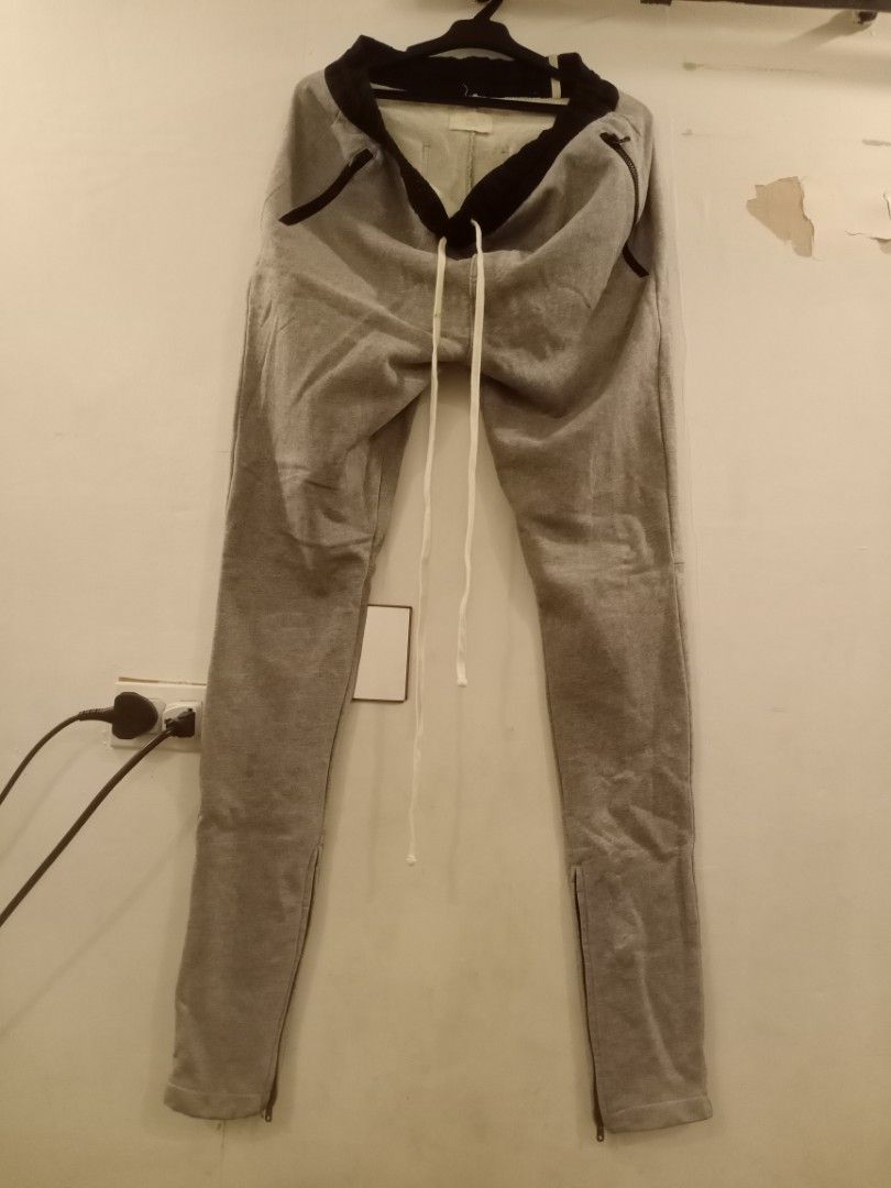 Fear of God Essentials Sweatpants (Category: Joggers) located in Manila. Submitted by thriftnmeal (Listing ID 1430183348, Image 1). Description: Gray sweatpants from Fear of God Essentials. Features a drawstring waist, black accents, and zippers at the ankles. The Essentials logo is visible on the tag. Made in China. Size L..
