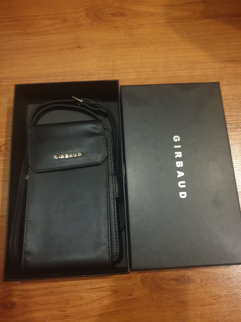 Girbaud Black Leather Sling Wallet (Category: Wallets & Card holders) located in Quezon City. Submitted by aredattic (Listing ID 1430159703, Image 1). Description: Black wallet by Girbaud. It features multiple card slots, a clear ID window, and a snap closure. Includes a detachable bag strap and comes with its original box. Flaw: peeling leather Rfs: decluttering old bags.