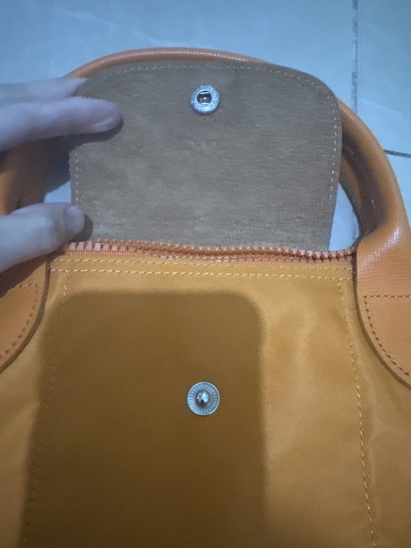 Longchamp Orange Handbag with Shoulder Strap (Category: Luxury Bags & Wallets) located in Malabon City. Submitted by jessibells (Listing ID 1430150214, Image 2). Description: Orange Longchamp handbag with a flap closure and a top handle. It features a zipper closure and includes a detachable shoulder strap. The interior has a pocket. The hardware is silver-toned..