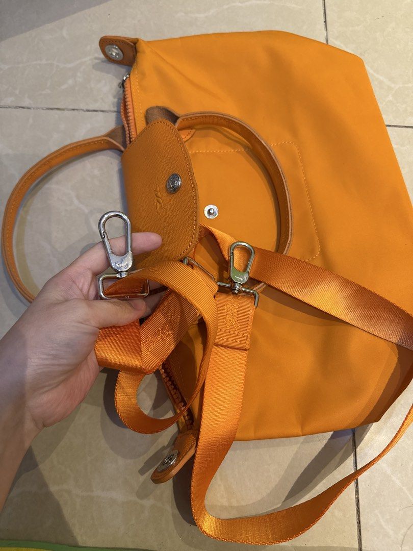 Longchamp Orange Handbag with Shoulder Strap (Category: Luxury Bags & Wallets) located in Malabon City. Submitted by jessibells (Listing ID 1430150214, Image 3). Description: Orange Longchamp handbag with a flap closure and a top handle. It features a zipper closure and includes a detachable shoulder strap. The interior has a pocket. The hardware is silver-toned..