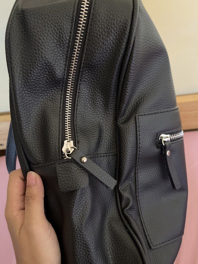 Mango Black Leather Backpack (Category: Backpacks) located in Muntinlupa City. Submitted by grace.declutters (Listing ID 1430072315, Image 3). Description: PLEASE READ - Black Mango backpack with a textured finish. - Has 1 big zippered compartment and 1 small zippered pocket - Chained (silver) and leather shoulder straps. - Has top handle The interior has a small zippered pocket as well. - can fit a 13-inch laptop but recommended for ipad and/not