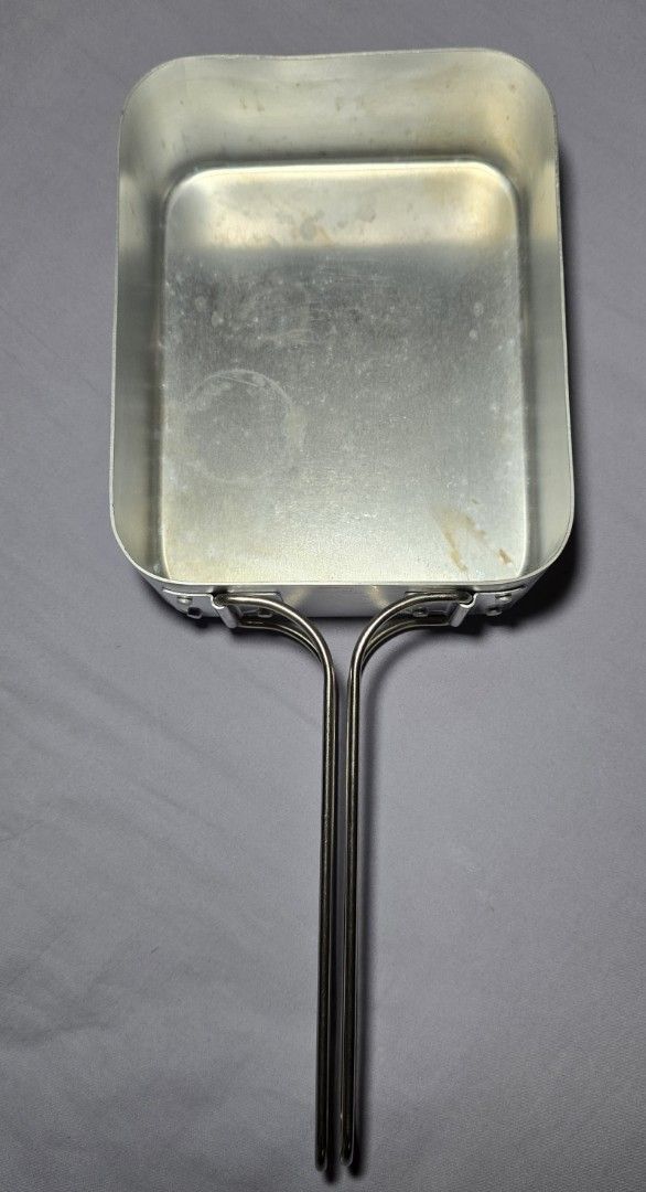 Mass tin (Category: Cookware & Accessories) located in Singapore. Submitted by xtrao (Listing ID 1430183708, Image 1). Description: Vintage aluminum cooking pan is perfect for camping or small cooking tasks. It features a sturdy handle for easy use. The pan shows some signs of wear, adding to its vintage charm. Great for heating up food or cooking small portions..