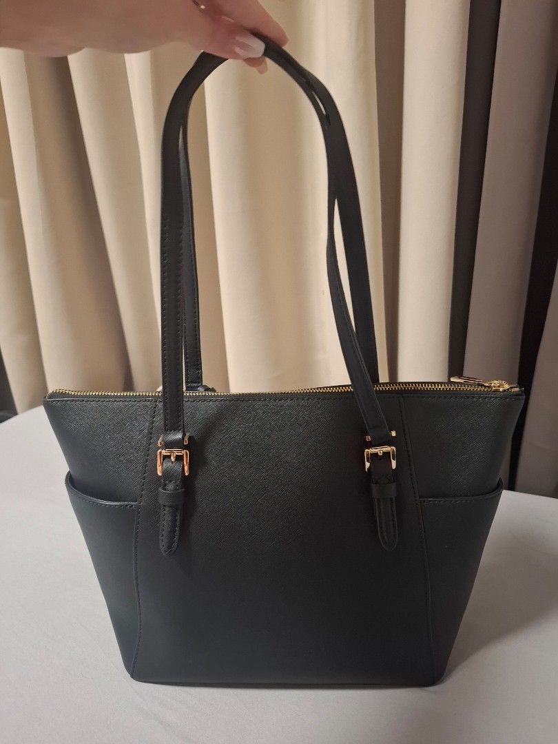 Michael Kors Black Tote Bag (Category: Luxury Bags & Wallets) located in Pasig City. Submitted by bevvvvy (Listing ID 1430048541, Image 2). Description: Michael Kors Charlotte Tote Bag – Black Slightly used and still in very good condition. This classic and elegant Michael Kors Charlotte tote is perfect for everyday use—especially for office or business settings. It features multiple interior pockets to keep your essentials organized, plus a spac