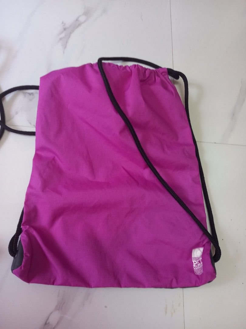 Nike Drawstring Bag (Category: Backpacks) located in Tuguegarao City. Submitted by zenphoenix-7ad615 (Listing ID 1430051724, Image 3). Description: Drawstring bag features a vibrant purple and black color scheme with the iconic Nike logo. It also has a white bag with a black design and a small zippered pocket. The bag is designed with drawstring closure for easy access and secure storage. Perfect for carrying your essentials in style. bundle of 2
