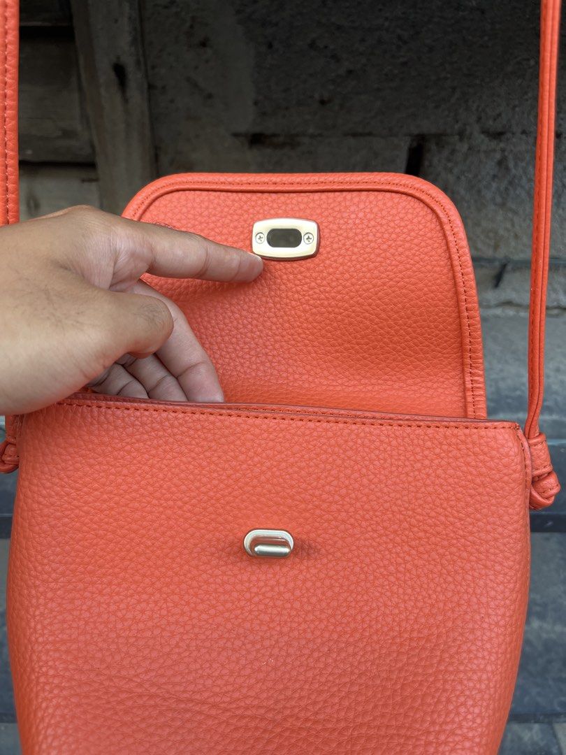 Orange Crossbody Bag with Shoulder Strap (Category: Cross-body Bags) located in Sultan Kudarat. Submitted by c_jay28 (Listing ID 1430071242, Image 3). Description: Orange crossbody bag features a textured exterior and a secure clasp closure. It has a long shoulder strap for easy carrying. Inside, there are multiple compartments for organizing your essentials, including card slots..