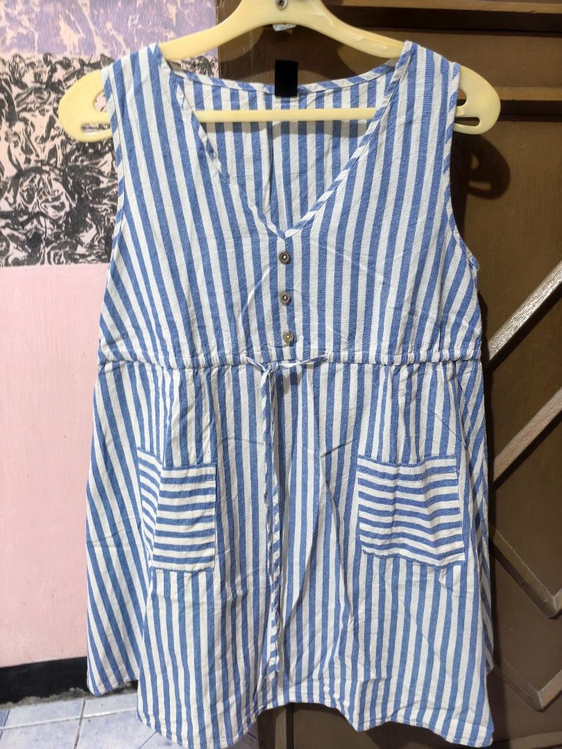 Shein Striped Sleeveless Top with Pockets (Category: Sleeveless) located in Dinalupihan. Submitted by colinnoceda (Listing ID 1430079758, Image 1). Description: Sleeveless mini dress features a blue and white striped pattern. It has a V-neckline with button details and a drawstring waist. The top includes two front pockets. The back of the top also has the same striped pattern. It is a casual and comfortable piece 💙🪻.
