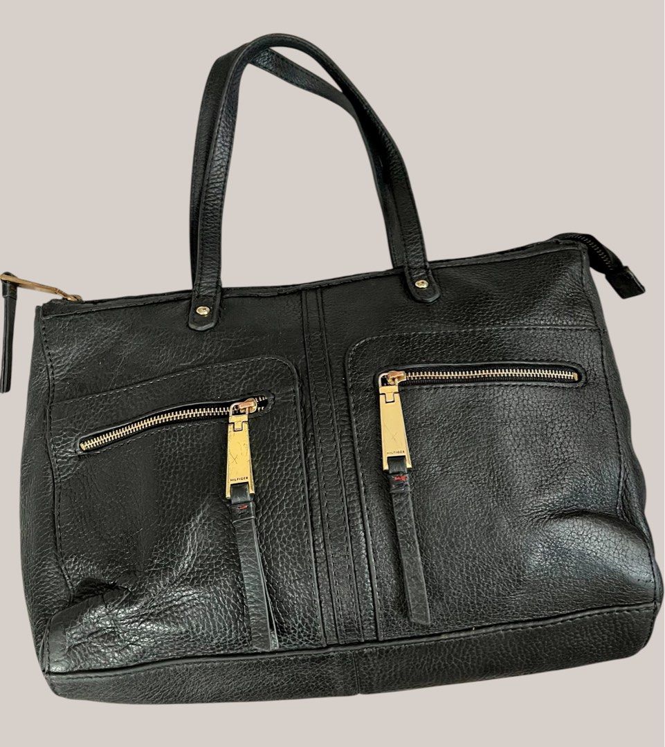 Tommy Hilfiger Black Leather Tote Bag (Category: Tote Bags) located in Pasig City. Submitted by zen_it_all (Listing ID 1422754807, Image 1). Description: - Tommy Hilfiger black leather tote bag - Two front zippered pockets - Top zipper closure - Navy fabric lining with red trim - Interior pocket with Tommy Hilfiger label - Gold-toned hardware - Dual top handles -plus sf -no rush shipping .