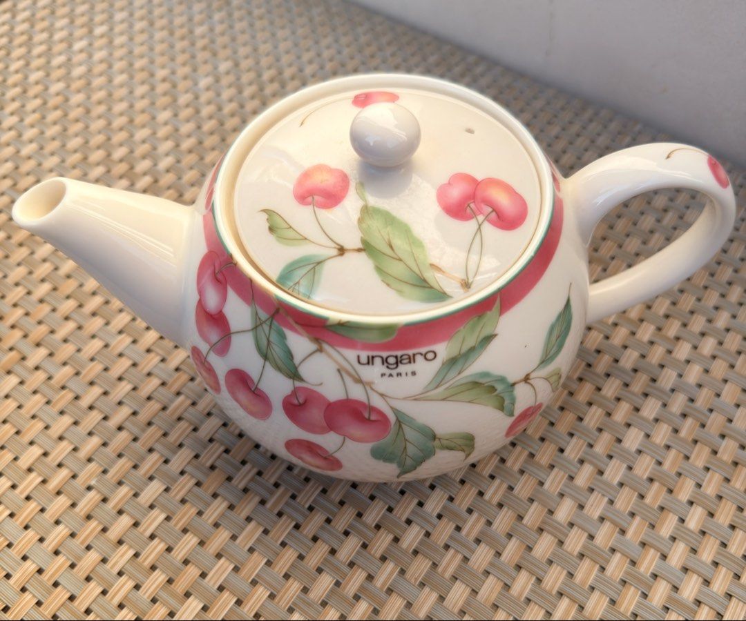 Ungaro Paris Cherry Teapot (Category: Coffee & Tea Tableware) located in Bulacan. Submitted by fancy.surplusera (Listing ID 1430067834, Image 2). Description: Elegant Ungaro Paris teapot featuring a charming cherry design. The teapot has a white base with a pink ribbon detail and cherry illustrations. It includes a lid with a matching cherry pattern and a comfortable handle. Perfect for serving tea in style. Condition: 9/10 Size: Price is per pie