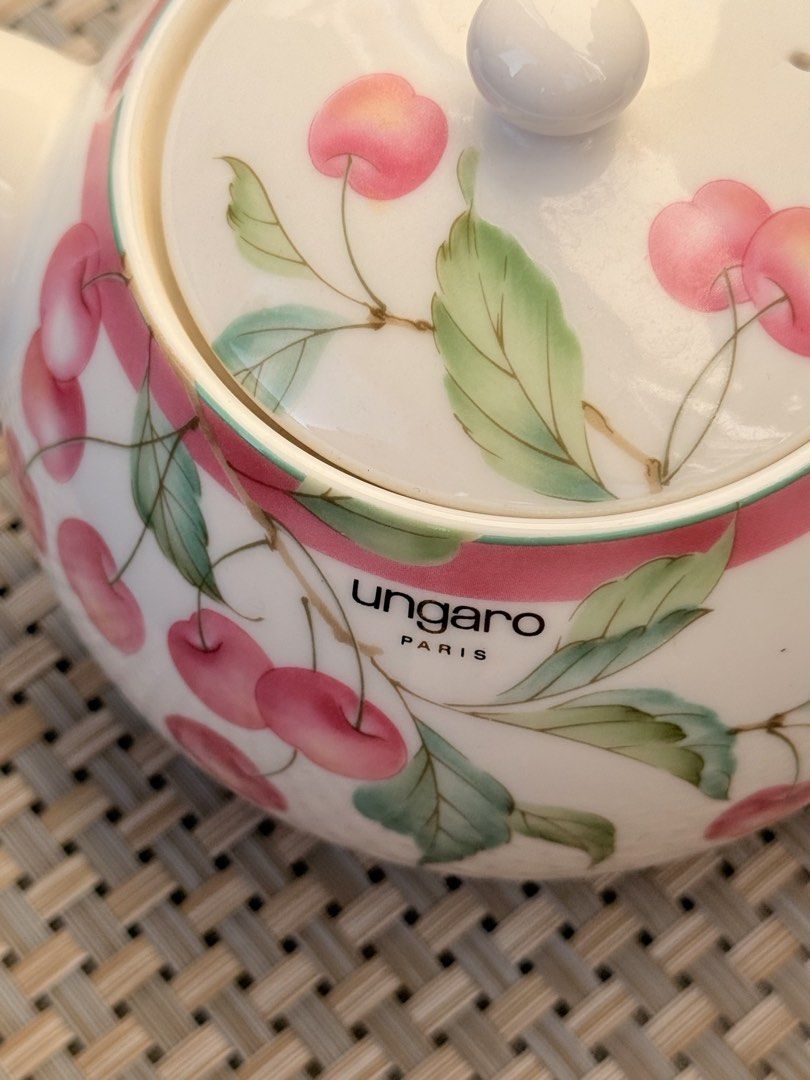 Ungaro Paris Cherry Teapot (Category: Coffee & Tea Tableware) located in Bulacan. Submitted by fancy.surplusera (Listing ID 1430067834, Image 3). Description: Elegant Ungaro Paris teapot featuring a charming cherry design. The teapot has a white base with a pink ribbon detail and cherry illustrations. It includes a lid with a matching cherry pattern and a comfortable handle. Perfect for serving tea in style. Condition: 9/10 Size: Price is per pie