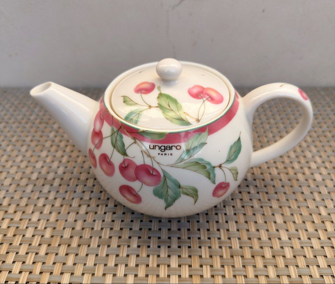 Ungaro Paris Cherry Teapot (Category: Coffee & Tea Tableware) located in Bulacan. Submitted by fancy.surplusera (Listing ID 1430067834, Image 1). Description: Elegant Ungaro Paris teapot featuring a charming cherry design. The teapot has a white base with a pink ribbon detail and cherry illustrations. It includes a lid with a matching cherry pattern and a comfortable handle. Perfect for serving tea in style. Condition: 9/10 Size: Price is per pie