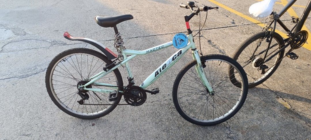 Alo CA Mountain Bike - Mint Green (Category: Bicycles) located in Singapore. Submitted by tonmoy491010813 (Listing ID 1430216873, Image 2). Description: Mint green Alo CA mountain bike. Features a black seat, rear fender, and a kickstand. Perfect for casual rides. Some signs of wear and tear visible..