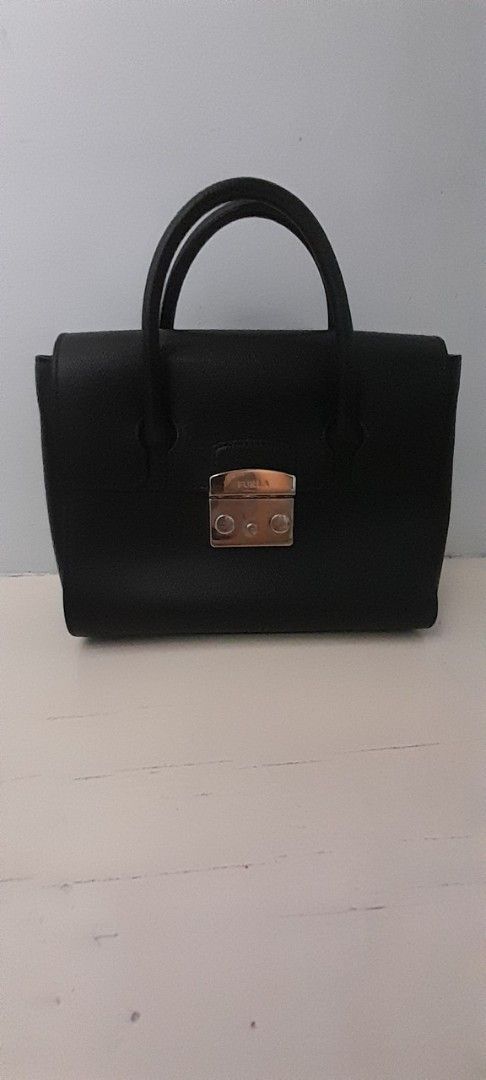 Furla Black Handbag (Category: Luxury Bags & Wallets) located in San Fernando. Submitted by peedeebee (Listing ID 1430275893, Image 1). Description: Furla preloved black bag no sling included good condition width 9inches no cop ships next day interior suede lining medyo namuti you may refresh or recolor sa maselan di ko na fix coz i dont know how, i bought it preloved na ganyan na sya otherwise its in very good condition minimal tarnish on hardwa