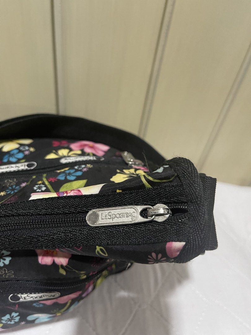 LeSportsac Floral Shoulder Bag (Category: Luxury Bags & Wallets) located in Mandaluyong City. Submitted by kately18 (Listing ID 1430339978, Image 2). Description: LeSportsac shoulder bag features a vibrant floral pattern on a black background. It has multiple zippered compartments for organization. The bag includes a shoulder strap and the LeSportsac logo is visible on the zippers..