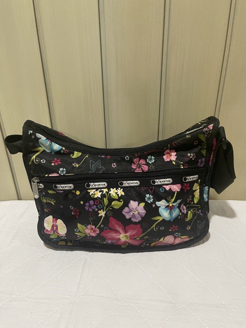 LeSportsac Floral Shoulder Bag (Category: Luxury Bags & Wallets) located in Mandaluyong City. Submitted by kately18 (Listing ID 1430339978, Image 1). Description: LeSportsac shoulder bag features a vibrant floral pattern on a black background. It has multiple zippered compartments for organization. The bag includes a shoulder strap and the LeSportsac logo is visible on the zippers..