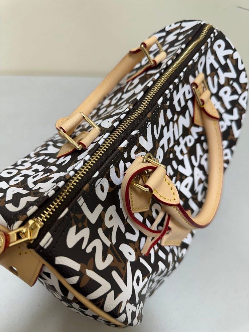 LV Graffiti Speedy 30 (Category: Luxury Bags & Wallets) located in Los Banos. Submitted by ditasbautista2329 (Listing ID 1430290685, Image 2). Description: Lv Speedy 30 handbag with graffiti print. Features a top zip closure, dual top handles, and an adjustable shoulder strap. The interior is lined with brown fabric. Includes a luggage tag. The hardware is gold-toned. The date code is SP0168..