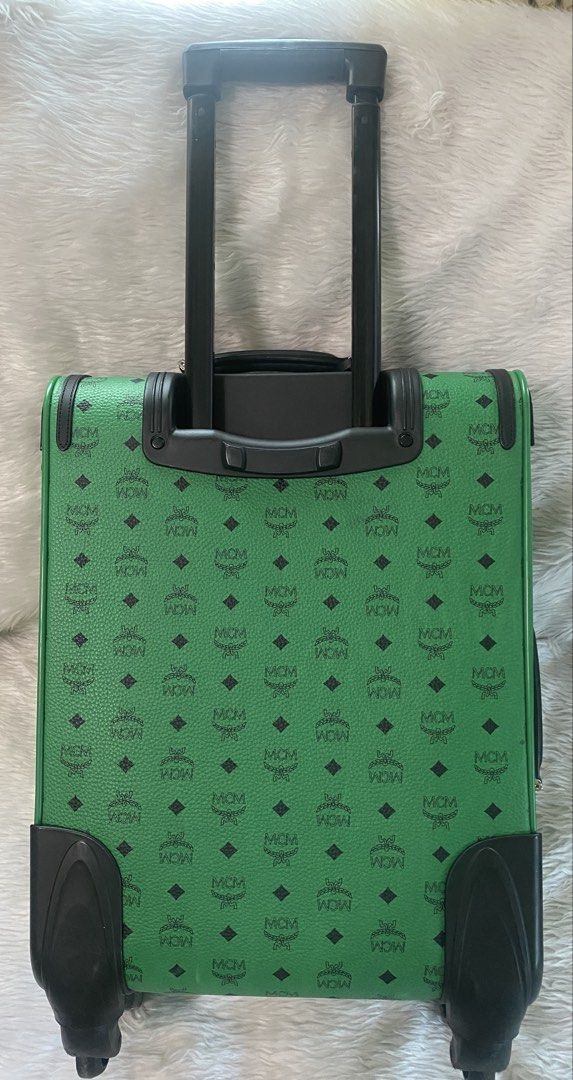 MCM Green Rolling Luggage (Category: Luxury Bags & Wallets) located in Malolos. Submitted by yamaguchionline (Listing ID 1430268122, Image 2). Description: -Green MCM rolling luggage with the MCM logo pattern. -Features a retractable handle, wheels, and a front pocket. Includes a top handle and a side handle. -The interior has multiple compartments and a zippered pocket. -The luggage has a lock and a metal plate with the MCM logo and serial numbe