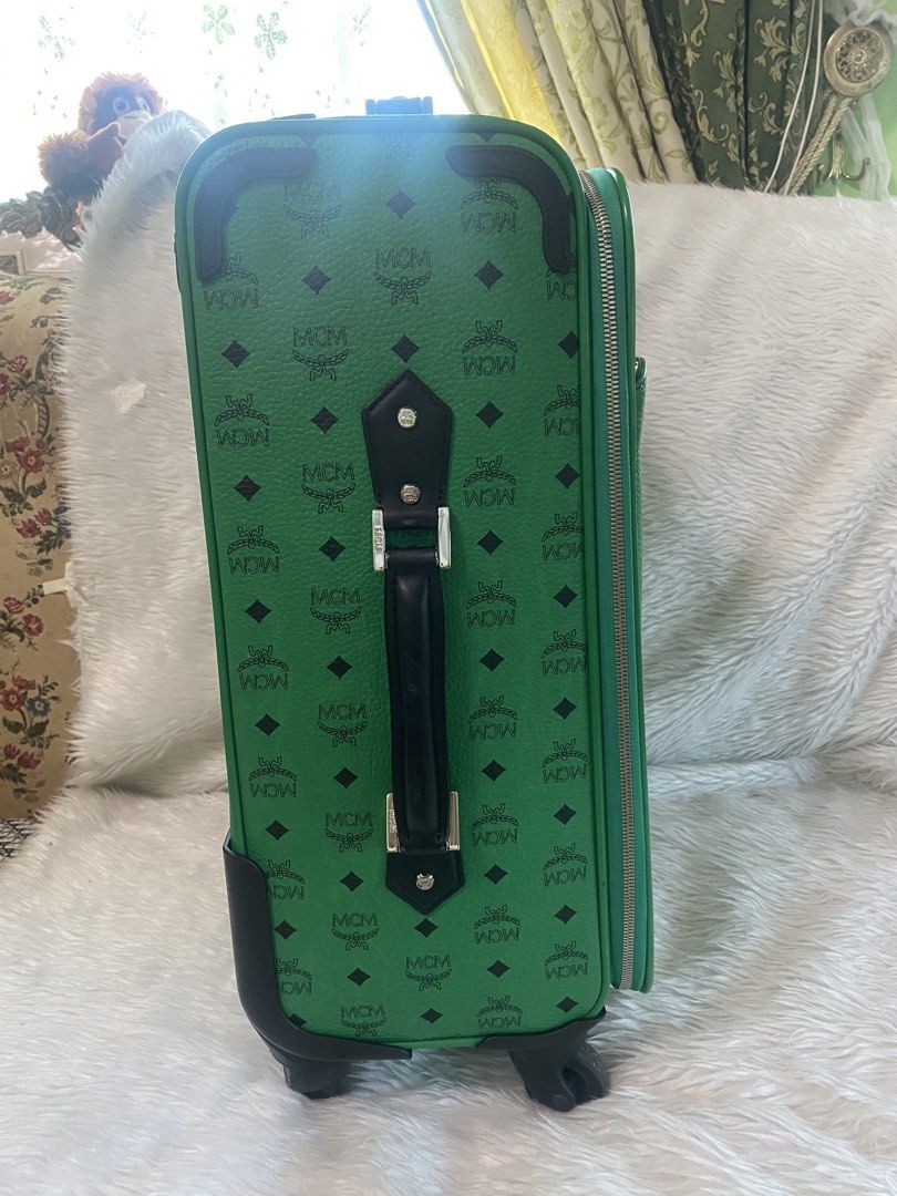 MCM Green Rolling Luggage (Category: Luxury Bags & Wallets) located in Malolos. Submitted by yamaguchionline (Listing ID 1430268122, Image 3). Description: -Green MCM rolling luggage with the MCM logo pattern. -Features a retractable handle, wheels, and a front pocket. Includes a top handle and a side handle. -The interior has multiple compartments and a zippered pocket. -The luggage has a lock and a metal plate with the MCM logo and serial numbe