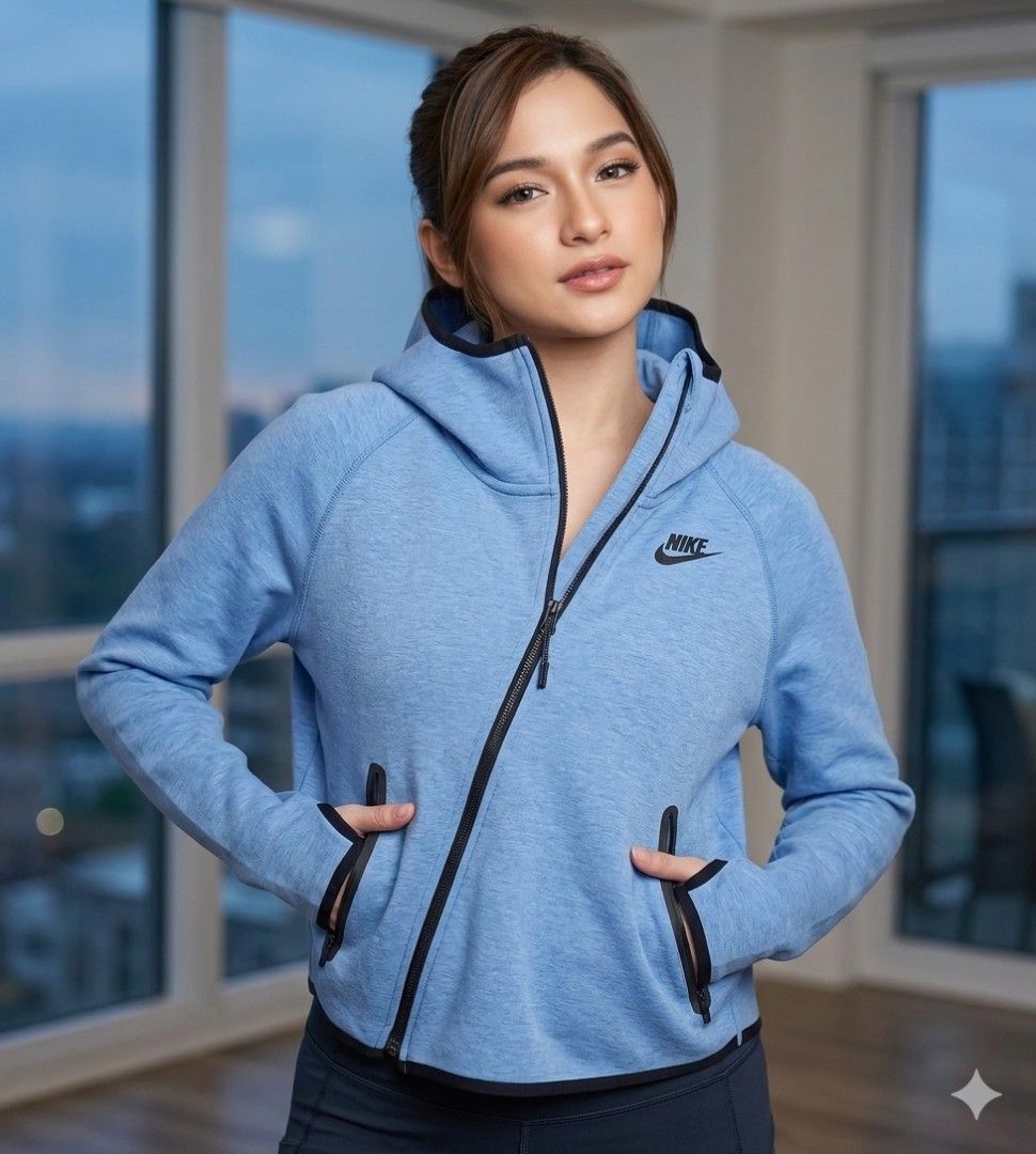 Nike Tech Fleece Hoodie Jacket XL (Category: Coats, Jackets and Outerwear) located in Bacoor. Submitted by toffs16 (Listing ID 1430214866, Image 2). Description: Nike Tech Fleece hoodie jacket in a light blue color. Features a unique diagonal zipper design, two front pockets, and a hood. The jacket has black accents along the zipper and pockets. The Nike logo is visible on the chest. Size XL..