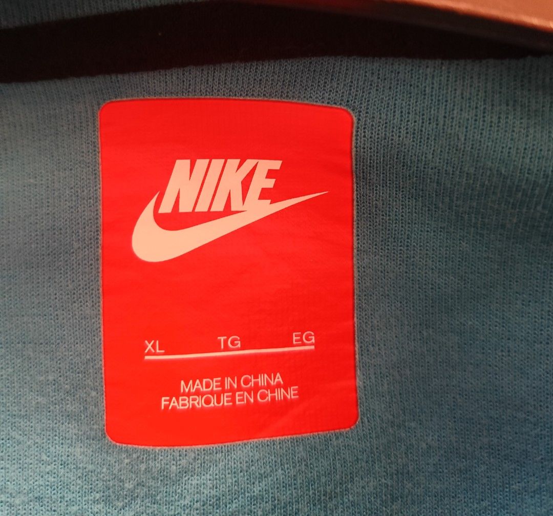 Nike Tech Fleece Hoodie Jacket XL (Category: Coats, Jackets and Outerwear) located in Bacoor. Submitted by toffs16 (Listing ID 1430214866, Image 3). Description: Nike Tech Fleece hoodie jacket in a light blue color. Features a unique diagonal zipper design, two front pockets, and a hood. The jacket has black accents along the zipper and pockets. The Nike logo is visible on the chest. Size XL..