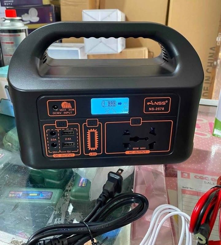 NSS NS-2578 Portable Power Station (Category: Electrical, Adaptors & Sockets) located in Manila. Submitted by emil_online_shop (Listing ID 1430345396, Image 2). Description: NSS NS-2578 portable power station features a built-in 150W inverter. It has AC and DC outputs, including USB ports. The device is compatible with various electronics like cameras, phones, and laptops. It comes with a solar panel, charging cables, and crocodile clips. It also