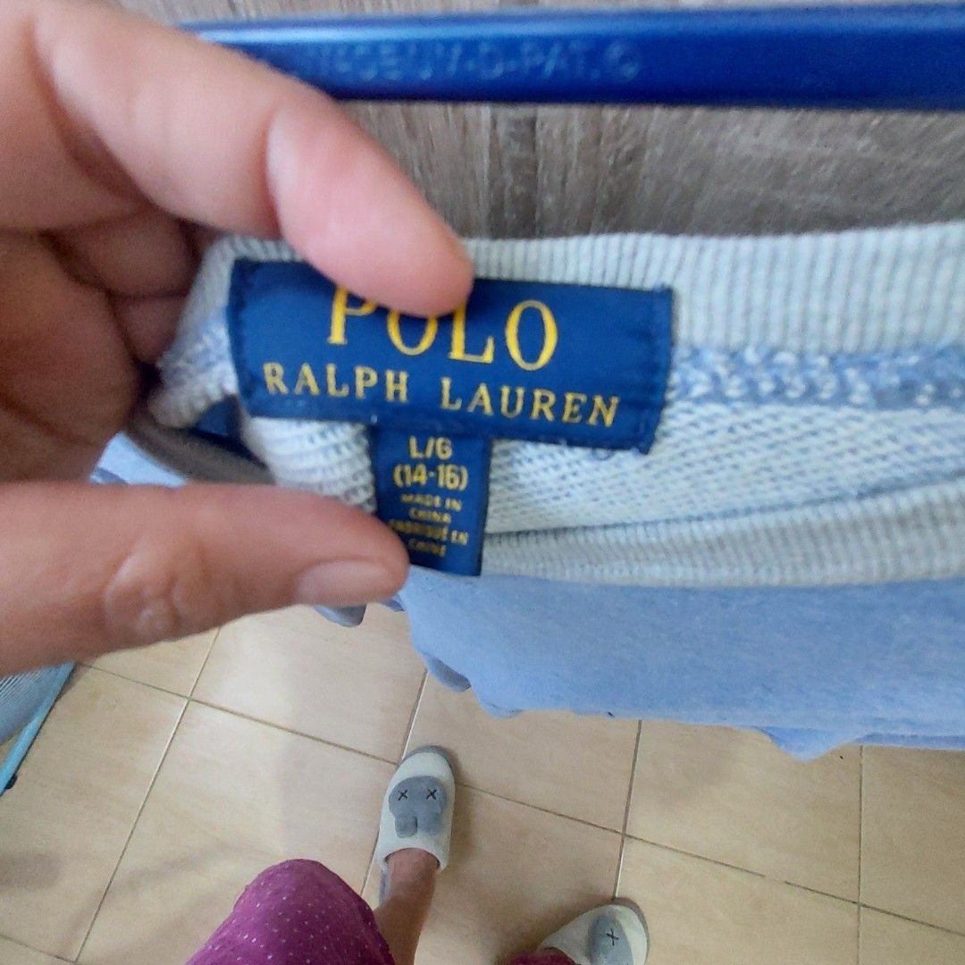Polo Ralph Lauren Sweatshirt - Blue (Category: Coats, Jackets and Outerwear) located in Antipolo. Submitted by uncovidspace (Listing ID 1430251070, Image 2). Description: Polo Ralph Lauren sweatshirt is a light blue color. It features a crew neck with a grey trim. The size is L/G (14-16). The Polo logo is visible on the chest. The sweatshirt has a pocket on the side..