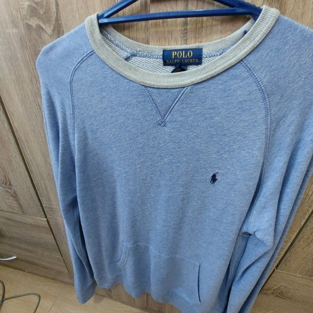 Polo Ralph Lauren Sweatshirt - Blue (Category: Coats, Jackets and Outerwear) located in Antipolo. Submitted by uncovidspace (Listing ID 1430251070, Image 1). Description: Polo Ralph Lauren sweatshirt is a light blue color. It features a crew neck with a grey trim. The size is L/G (14-16). The Polo logo is visible on the chest. The sweatshirt has a pocket on the side..