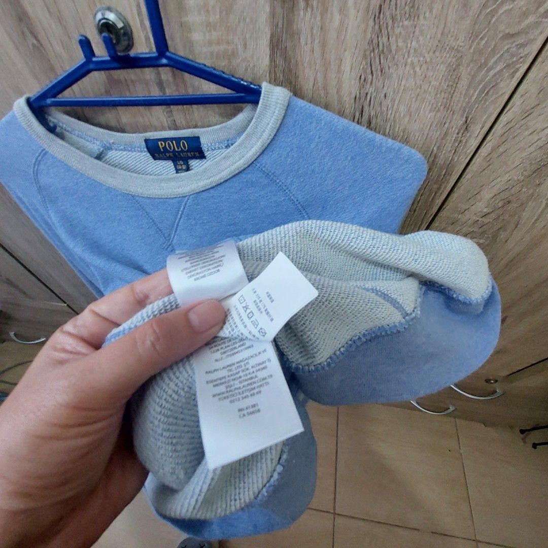 Polo Ralph Lauren Sweatshirt - Blue (Category: Coats, Jackets and Outerwear) located in Antipolo. Submitted by uncovidspace (Listing ID 1430251070, Image 3). Description: Polo Ralph Lauren sweatshirt is a light blue color. It features a crew neck with a grey trim. The size is L/G (14-16). The Polo logo is visible on the chest. The sweatshirt has a pocket on the side..