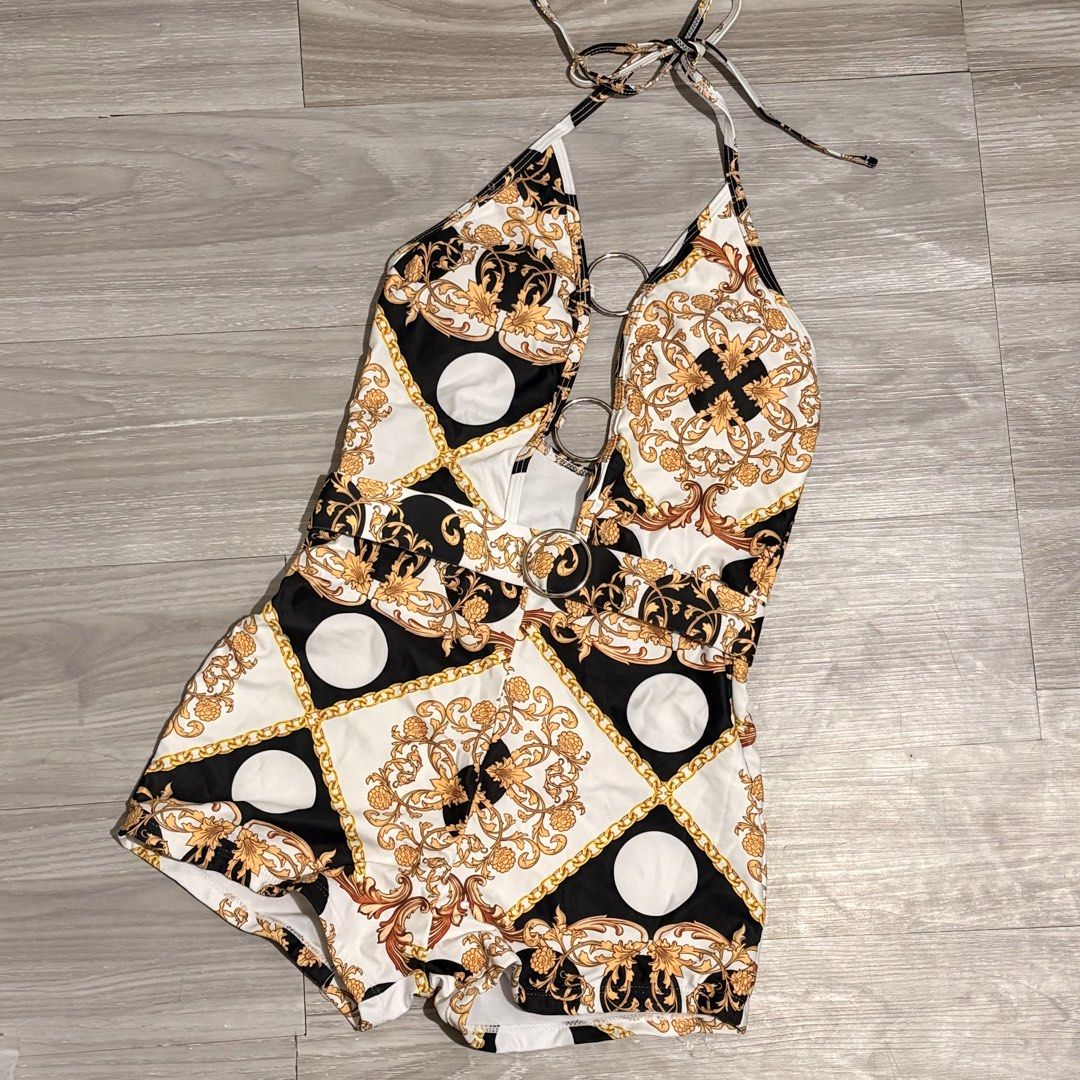 Printed Halter Neck Swimsuit - Size S (Category: Bikinis & Swimsuits) located in Tarlac. Submitted by shantirisque (Listing ID 1430263038, Image 1). Description: Stylish halter neck swimsuit One piece short with pads featuring a unique print with gold accents. It has ring and detachable belt details and a flattering design. The swimsuit is made of 82% Polyester and 18% Spandex. It is a size small. Perfect for your next beach trip or pool party!.