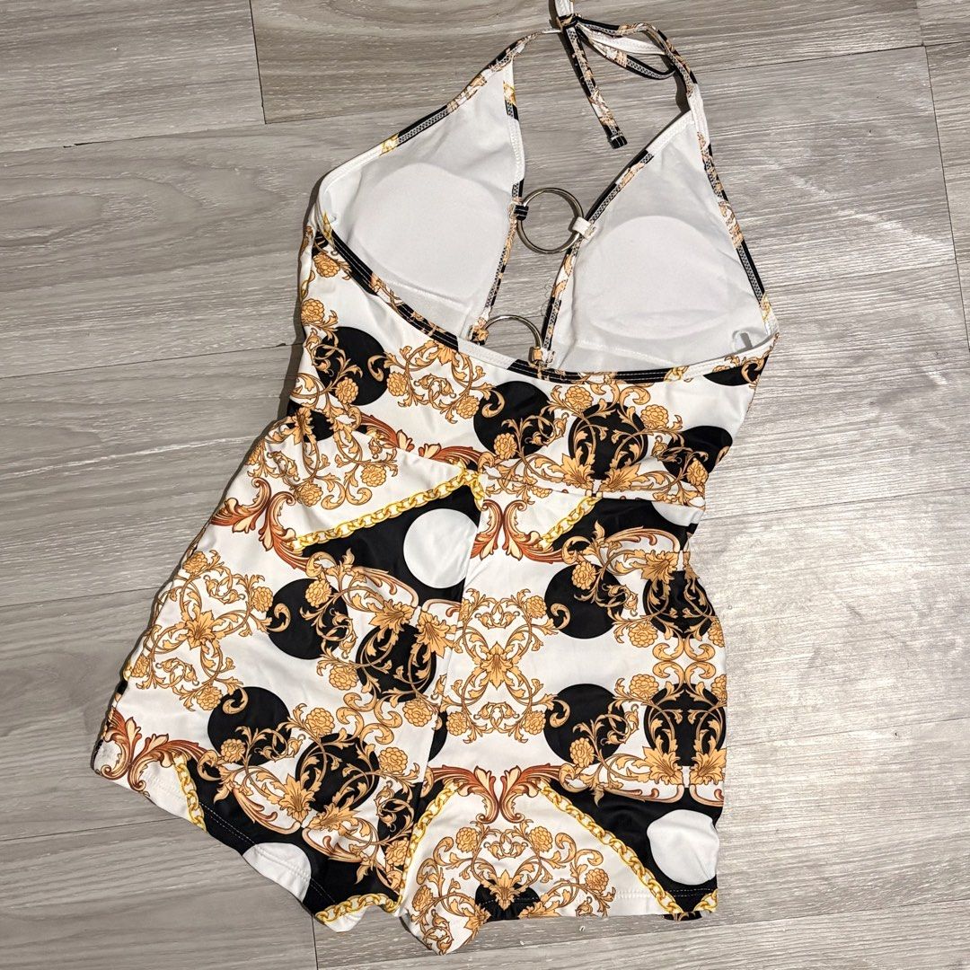 Printed Halter Neck Swimsuit - Size S (Category: Bikinis & Swimsuits) located in Tarlac. Submitted by shantirisque (Listing ID 1430263038, Image 3). Description: Stylish halter neck swimsuit One piece short with pads featuring a unique print with gold accents. It has ring and detachable belt details and a flattering design. The swimsuit is made of 82% Polyester and 18% Spandex. It is a size small. Perfect for your next beach trip or pool party!.