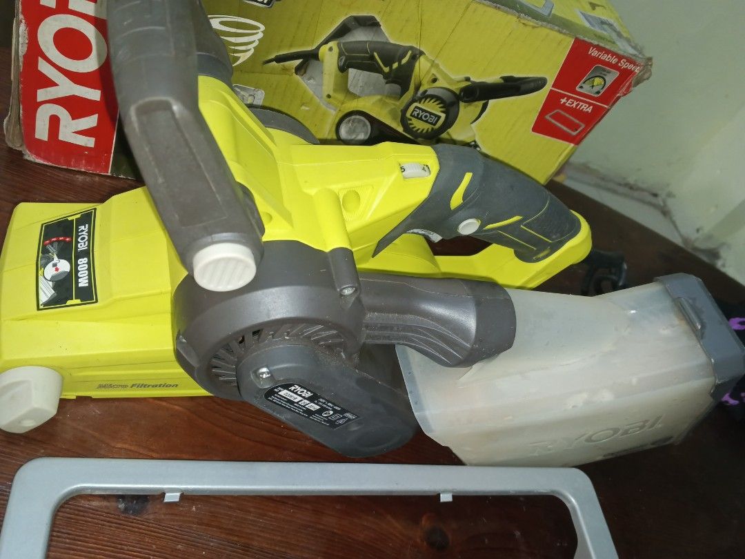 Ryobi 800W Belt Sander (Category: Belts) located in Caloocan City. Submitted by surplusandbnewshop (Listing ID 1430283423, Image 2). Description: Ryobi 800W belt sander with dust collection system. Includes the original box and a frame. Features variable speed control and micro filtration. The sander is yellow and gray. The dust collection container is included. The power cord is also included..