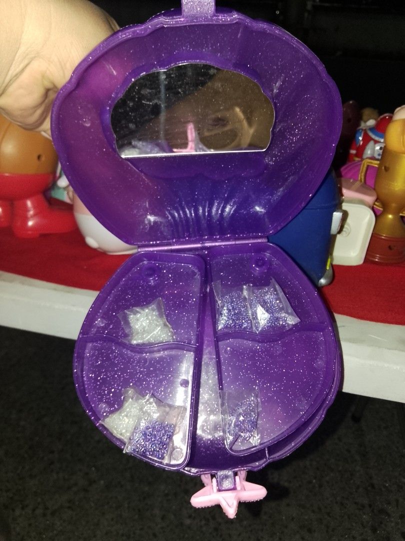 Vintage Disney Little Mermaid Shell Compact (Category: Wallets & Card holders) located in Davao. Submitted by Ysang40 (Listing ID 1430346782, Image 2). Description: Vintage Disney Little Mermaid shell compact features a purple exterior with a mermaid design. It opens to reveal a mirror and compartments with star-shaped accessories. The compact has a pink clasp and a glittery finish. The back of the compact has the Disney logo..