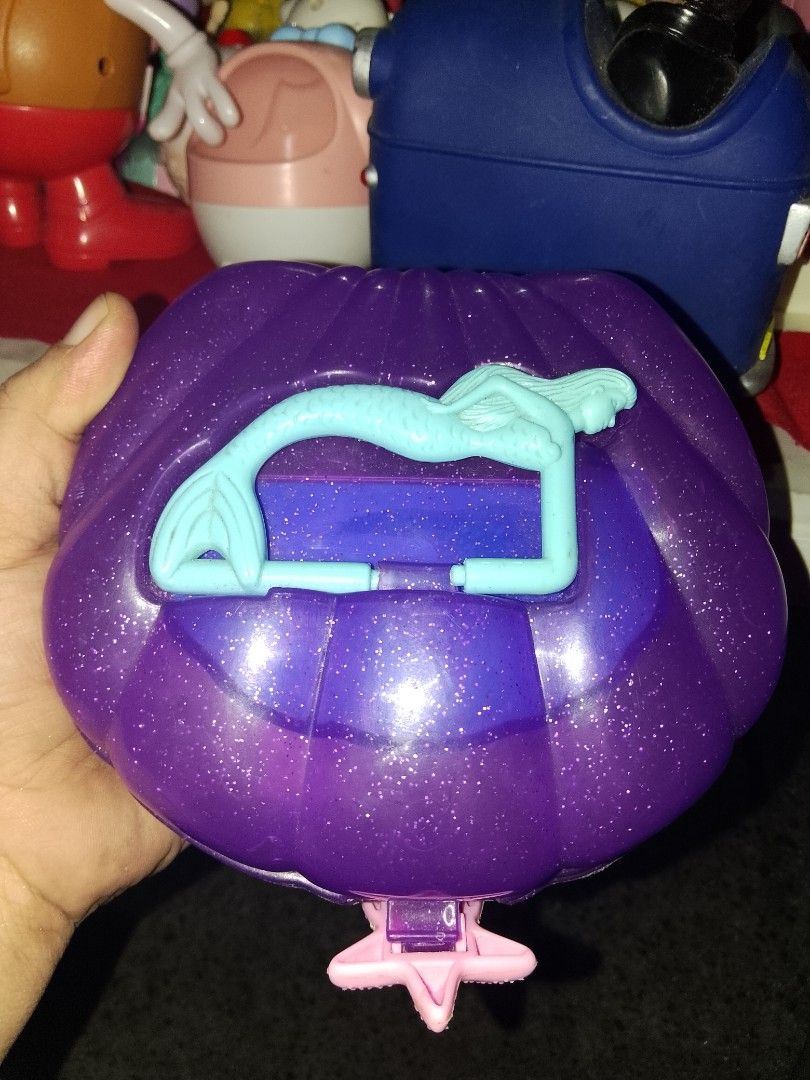 Vintage Disney Little Mermaid Shell Compact (Category: Wallets & Card holders) located in Davao. Submitted by Ysang40 (Listing ID 1430346782, Image 1). Description: Vintage Disney Little Mermaid shell compact features a purple exterior with a mermaid design. It opens to reveal a mirror and compartments with star-shaped accessories. The compact has a pink clasp and a glittery finish. The back of the compact has the Disney logo..