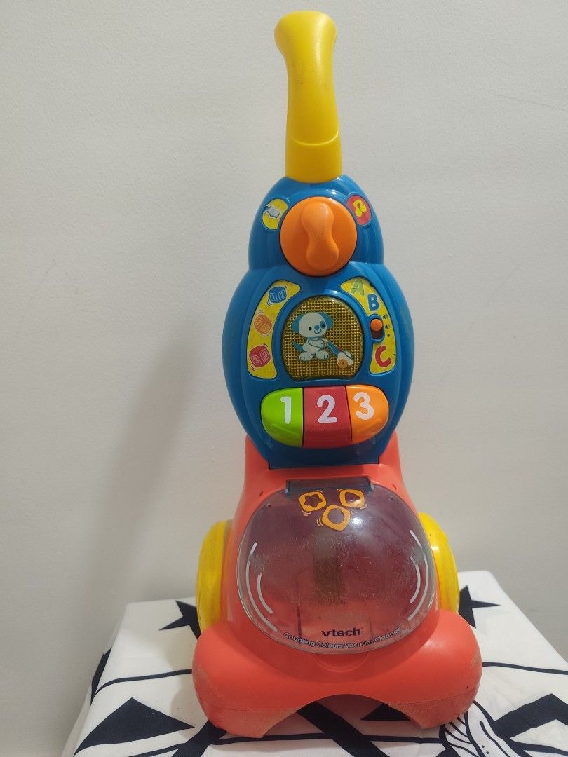 VTech Learning Vacuum Cleaner Toy (Category: Educational & Learning Toys) located in Cavite. Submitted by mdrjtb (Listing ID 1430315382, Image 1). Description: VTech learning vacuum cleaner toy features colorful buttons with numbers and letters. It has a handle and a clear compartment. The toy is designed with a red base, a blue body, and a yellow handle..