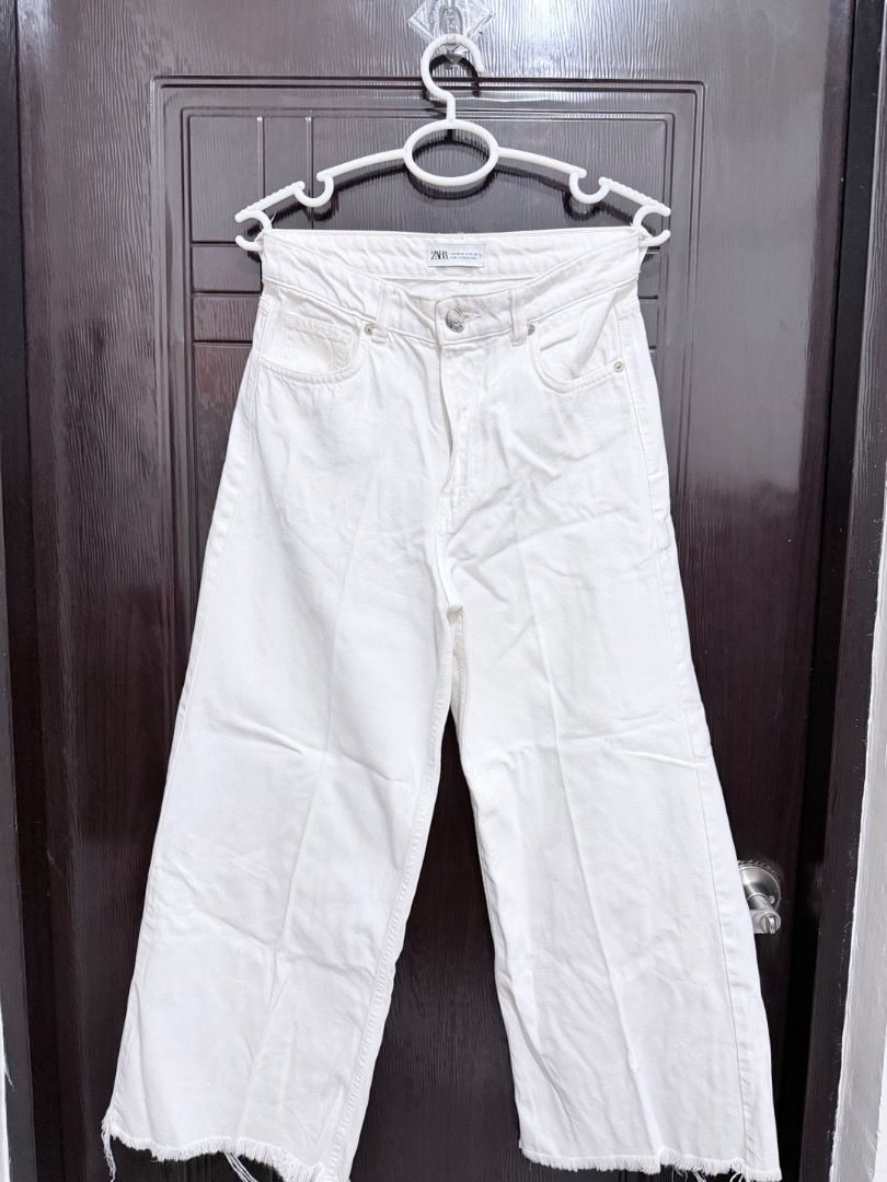 Zara White Culottes Jeans (Category: Jeans) located in Pasig City. Submitted by alwaysfaevored (Listing ID 1430397769, Image 2). Description: White culottes jeans from Zara. Features a high-waisted design with a button and zipper closure. The jeans have a wide leg and a raw hem. Perfect for a casual and stylish look. Made from a sturdy denim fabric..