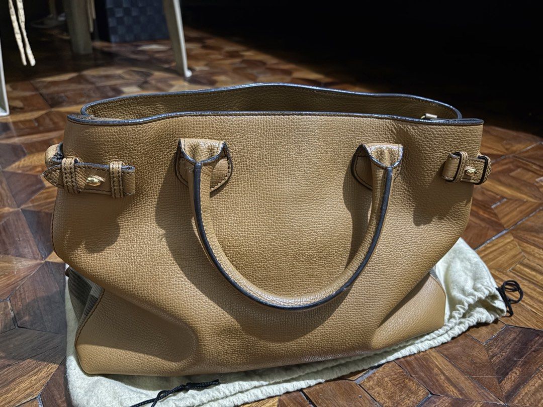 Burberry Banner House Check Medium Leather Tote (Category: Luxury Bags & Wallets) located in Quezon City. Submitted by ellemss (Listing ID 1430570096, Image 3). Description: Genuine Burberry handbag in a beautiful tan color. Features a top handle design with buckle details and a detachable shoulder strap. Includes a dust bag for storage. The interior has multiple compartments with a zipper closure. NO FLAWS and comes with dustbag. .