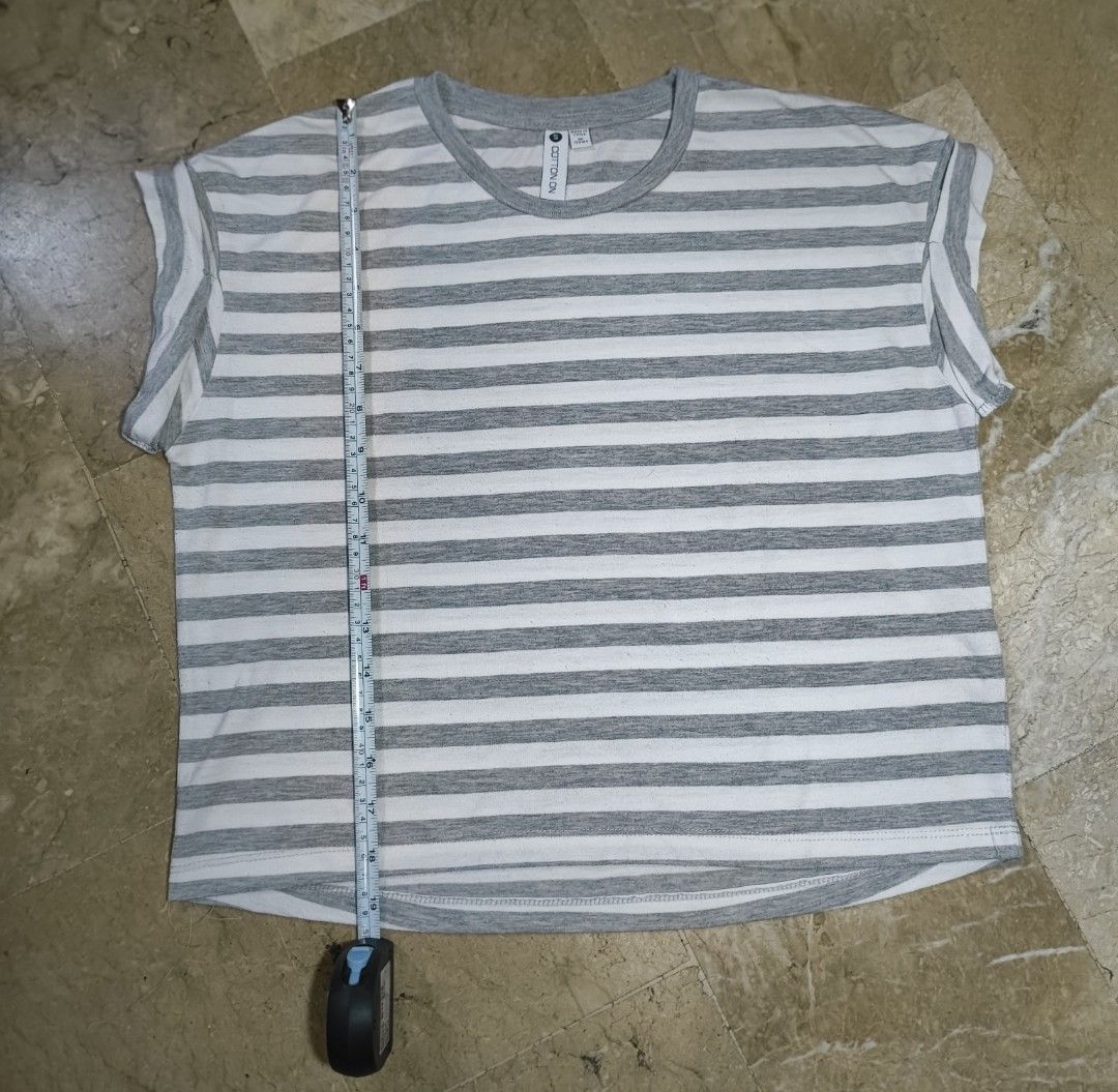 Cotton On Striped T-shirt (Category: Tshirts & Polo Shirts ) located in Caloocan City. Submitted by makyojs (Listing ID 1430545588, Image 1). Description: Gray and white striped t-shirt from Cotton On. Features a round neck and rolled sleeves. Size S. Measurements: 24 inches across the chest, 25 inches in length, and 7 inches sleeve length..