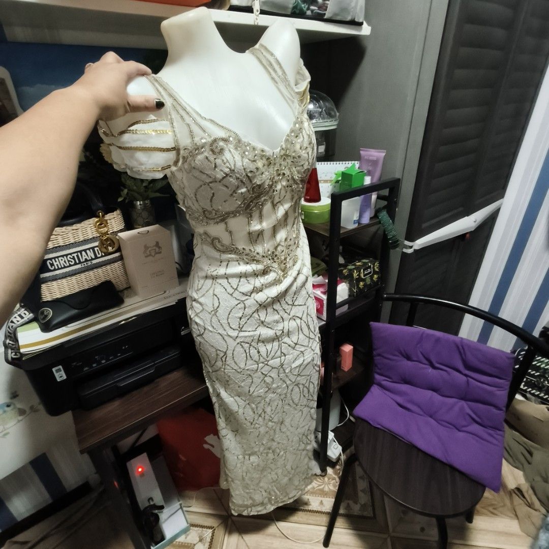 Elegant White Evening Dress (Category: Evening dresses & gowns) located in Manila. Submitted by stuff_finder (Listing ID 1430507307, Image 3). Description: Stunning white evening dress with intricate gold detailing. Features a flattering V-neckline and a high slit. The back has a corset-style closure for a customizable fit. The dress has delicate cap sleeves with gold accents. Perfect for special occasions..