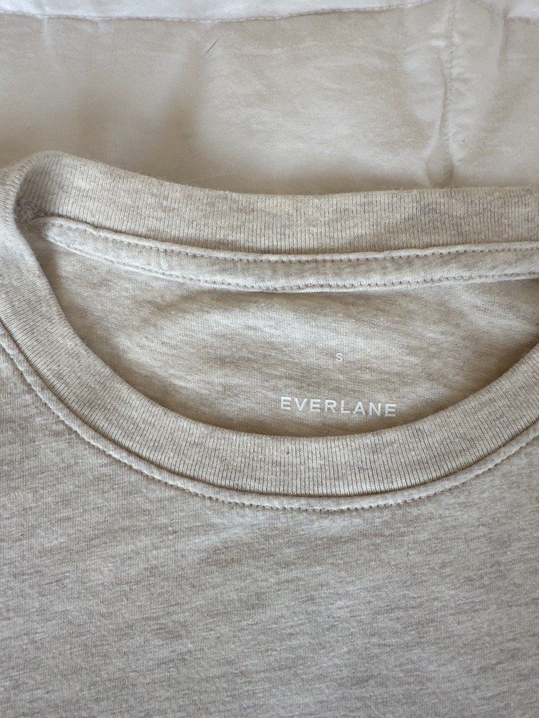 Everlane Crew Neck T-shirt S (Category: Shirts) located in Calamba. Submitted by naturesfield (Listing ID 1430404055, Image 3). Description: Everlane crew neck box cut t-shirt is a classic wardrobe staple. It features a round neckline and short sleeves. The shirt is a light beige color. The size is Small. Made from a soft, comfortable fabric, it's perfect for everyday wear. The Everlane logo is visible on the neckline. Bought for 2500. Slightly n