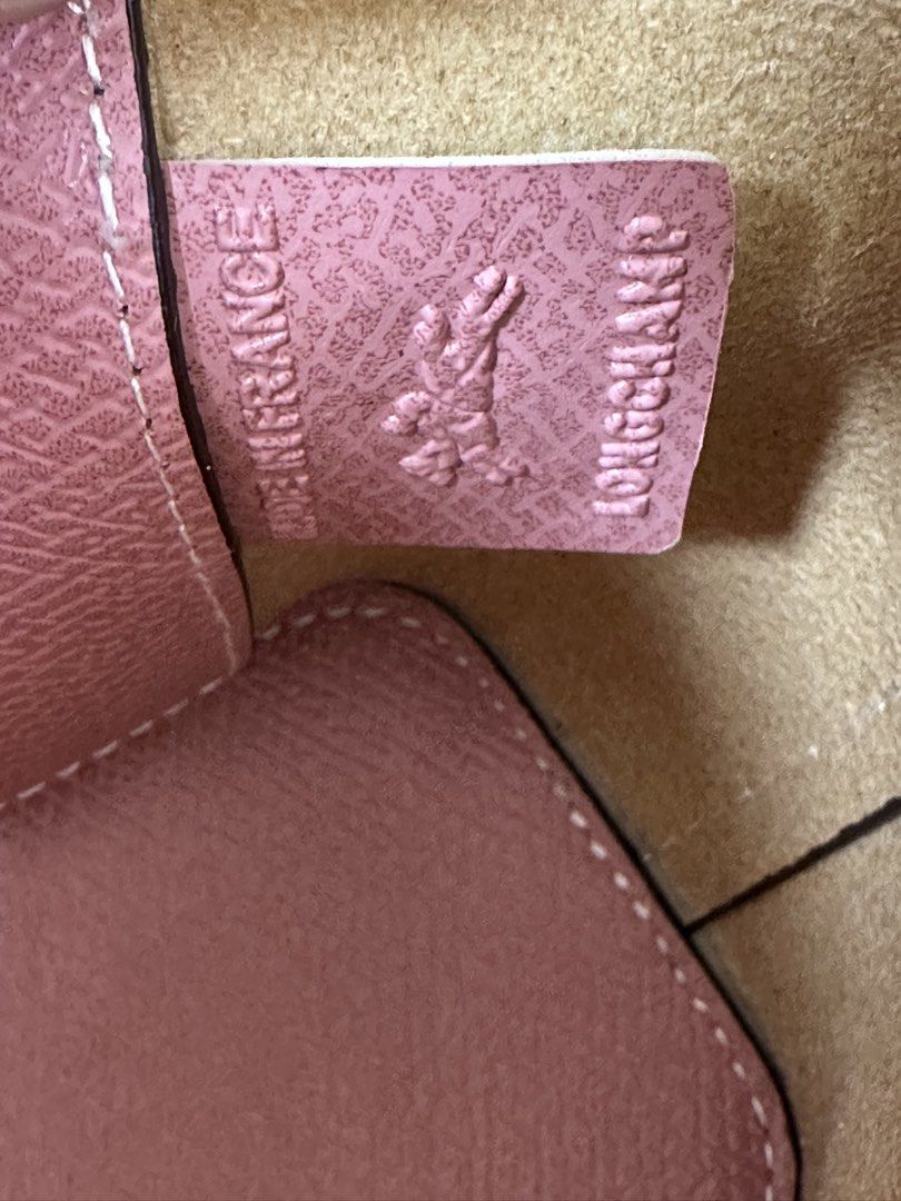Longchamp Roseau Handbag with Shoulder Strap (Category: Luxury Bags & Wallets) located in Los Banos. Submitted by ditasbautista2329 (Listing ID 1430438277, Image 3). Description: Longchamp Roseau handbag in a lovely pink color. Features a top handle and a detachable shoulder strap for versatile carrying options. The bag has a flap closure with a gold-tone clasp. Interior includes a slip pocket. Made in France. The bag has the Longchamp logo embos