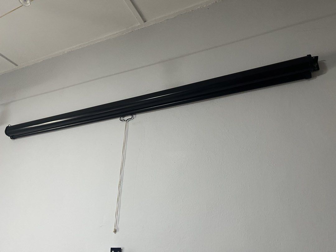 Manual Pull Down Projector Screen (Category: Projectors) located in Kuala Lumpur. Submitted by jemin (Listing ID 1430438491, Image 1). Description: Manual pull-down projector screen. It is black and white in color. The screen is mounted on the wall. It has a pull-down cord for easy operation. Width: 200cm.