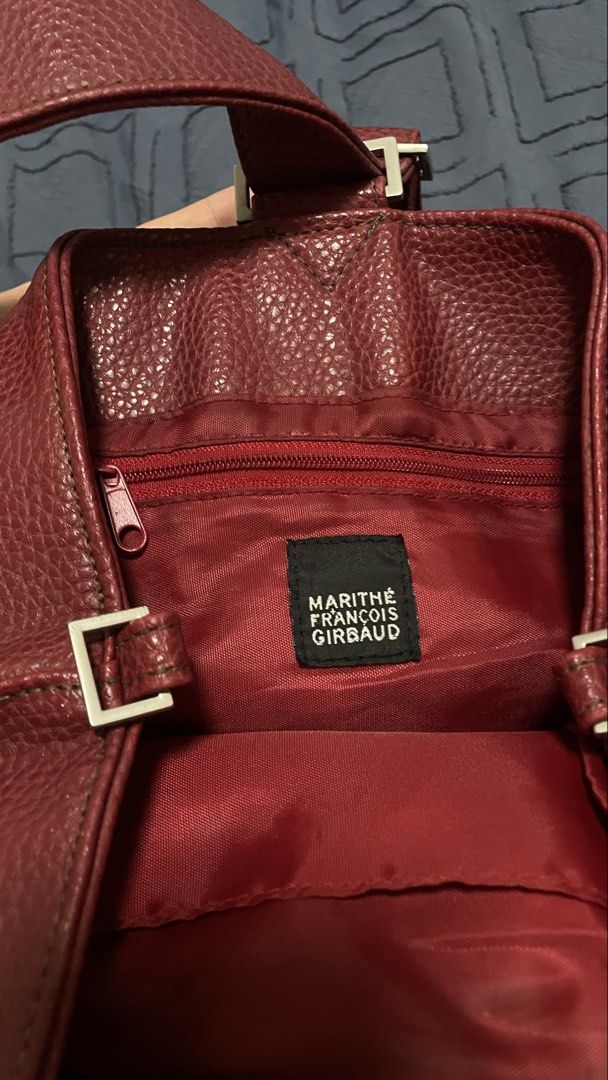 Marithe Francois Girbaud Red Handbag (Category: Luxury Bags & Wallets) located in Santa Rosa. Submitted by southstash.blvd (Listing ID 1430436077, Image 2). Description: Marithe Francois Girbaud handbag in a rich red color. Features a unique shape with a single strap and a buckle detail. The interior is lined with red fabric and includes a zipper. A stylish and functional accessory for everyday use..