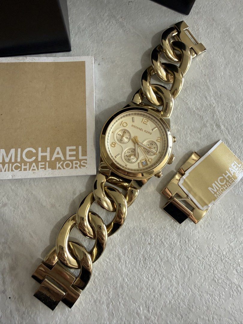 Michael Kors Gold Chain Watch (Category: Women's Watches) located in Quezon City. Submitted by cbake (Listing ID 1430445047, Image 2). Description: - Michael Kors gold-toned watch - Chain-link bracelet - Round face with sub-dials - Date display - Gold dial and bracelet - Includes original box - Comes with instruction card and tag.