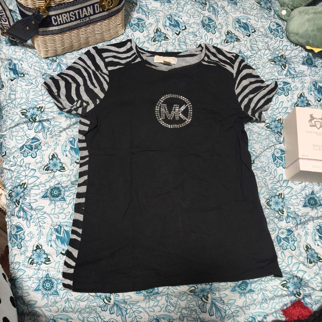 Michael Kors Zebra Print T-shirt (Category: Shirts) located in Manila. Submitted by stuff_finder (Listing ID 1430527876, Image 1). Description: Michael Kors T-shirt features a unique zebra print design. It has a black body with zebra print sleeves and side panels. The front showcases the MK logo embellished with rhinestones. The shirt is a size M..