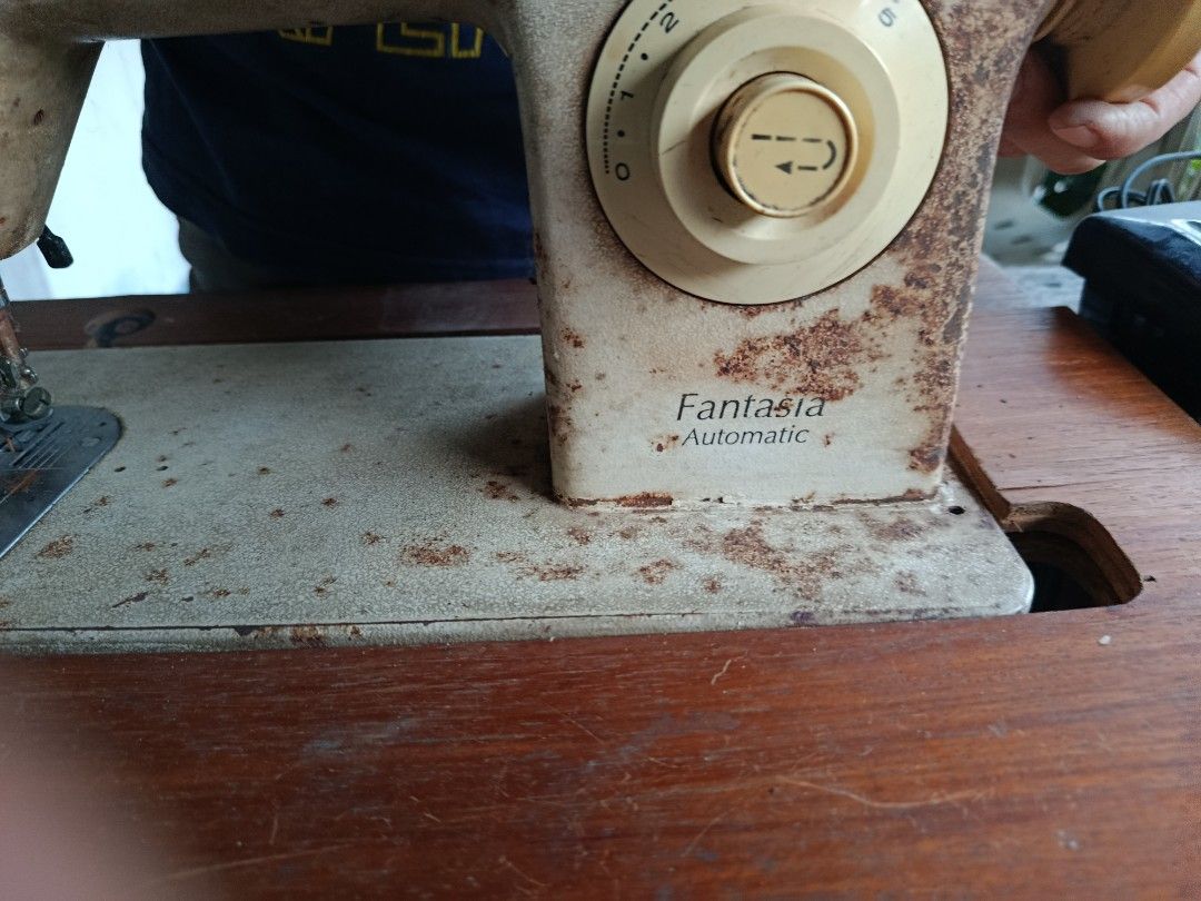 Singer Fantasia Automatic Sewing Machine (Category: Other Home Appliances) located in Quezon City. Submitted by bernadette_puyos16 (Listing ID 1430479697, Image 3). Description: Vintage Singer Fantasia Automatic sewing machine. Features a wooden table with drawers and a foot pedal. The machine has various stitch settings and a reverse function. The model number is 966. Includes the original Singer foot pedal..
