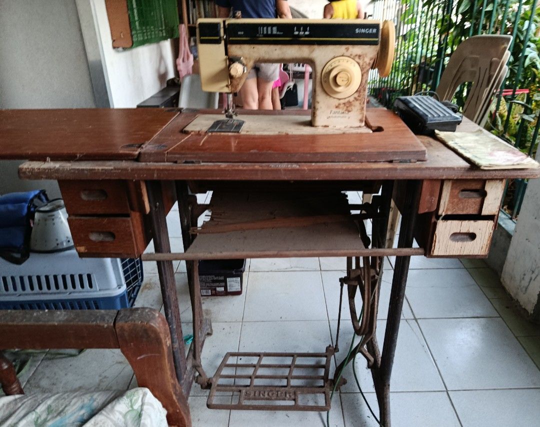 Singer Fantasia Automatic Sewing Machine (Category: Other Home Appliances) located in Quezon City. Submitted by bernadette_puyos16 (Listing ID 1430479697, Image 1). Description: Vintage Singer Fantasia Automatic sewing machine. Features a wooden table with drawers and a foot pedal. The machine has various stitch settings and a reverse function. The model number is 966. Includes the original Singer foot pedal..